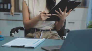 Modern atölyede yeni kıyafet koleksiyonu üzerinde çalışan profesyonel tasarımcı