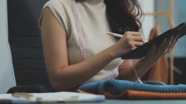 Modern atölyede yeni kıyafet koleksiyonu üzerinde çalışan profesyonel tasarımcı
