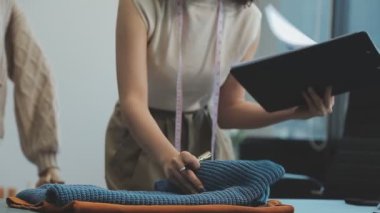 vlogger, blog yazarı küçük KOBİ iş kadını Asyalı güzel kadın kıyafetleri canlı yayın satışı internet üzerinden satışı, ana ofiste mevcut ürün detaylarını gösterme, girişimci ekommerce