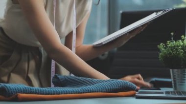 vlogger, blog yazarı küçük KOBİ iş kadını Asyalı güzel kadın kıyafetleri canlı yayın satışı internet üzerinden satışı, ana ofiste mevcut ürün detaylarını gösterme, girişimci ekommerce