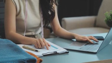 vlogger, blog yazarı küçük KOBİ iş kadını Asyalı güzel kadın kıyafetleri canlı yayın satışı internet üzerinden satışı, ana ofiste mevcut ürün detaylarını gösterme, girişimci ekommerce