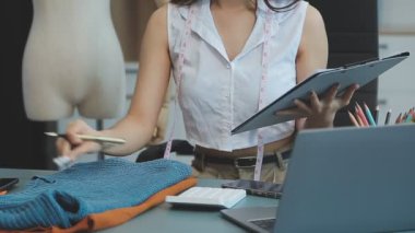 vlogger, blog yazarı küçük KOBİ iş kadını Asyalı güzel kadın kıyafetleri canlı yayın satışı internet üzerinden satışı, ana ofiste mevcut ürün detaylarını gösterme, girişimci ekommerce
