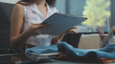 vlogger, blog yazarı küçük KOBİ iş kadını Asyalı güzel kadın kıyafetleri canlı yayın satışı internet üzerinden satışı, ana ofiste mevcut ürün detaylarını gösterme, girişimci ekommerce