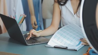 vlogger, blog yazarı küçük KOBİ iş kadını Asyalı güzel kadın kıyafetleri canlı yayın satışı internet üzerinden satışı, ana ofiste mevcut ürün detaylarını gösterme, girişimci ekommerce