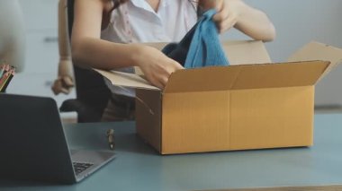 vlogger, blog yazarı küçük KOBİ iş kadını Asyalı güzel kadın kıyafetleri canlı yayın satışı internet üzerinden satışı, ana ofiste mevcut ürün detaylarını gösterme, girişimci ekommerce