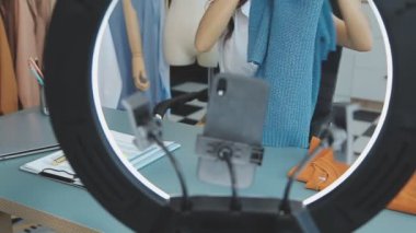 vlogger, blog yazarı küçük KOBİ iş kadını Asyalı güzel kadın kıyafetleri canlı yayın satışı internet üzerinden satışı, ana ofiste mevcut ürün detaylarını gösterme, girişimci ekommerce