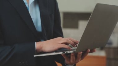 Modern ofiste dizüstü bilgisayarla çalışan bir iş adamı