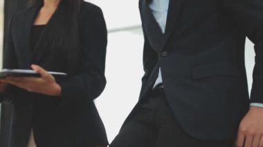 Bir grup genç iş adamı şık bir ofiste duruyor ve yeni proje, iş ve finans kavramını tartışıyorlar..