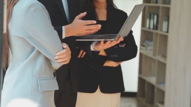 Bir grup genç iş adamı şık bir ofiste duruyor ve yeni proje, iş ve finans kavramını tartışıyorlar..