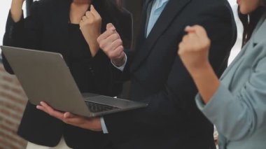 Bir grup genç iş adamı şık bir ofiste duruyor ve yeni proje, iş ve finans kavramını tartışıyorlar..