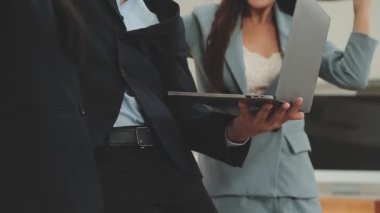 Bir grup genç iş adamı şık bir ofiste duruyor ve yeni proje, iş ve finans kavramını tartışıyorlar..