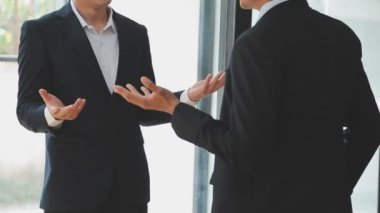 Bir grup genç iş adamı şık bir ofiste duruyor ve yeni proje, iş ve finans kavramını tartışıyorlar..