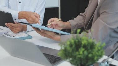 Finansal rapor üzerinde birlikte çalışan genç iş adamları şık bir ofiste iş ve finans temasını ön plana çıkarıyorlar..