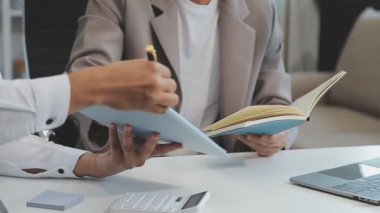 Finansal rapor üzerinde birlikte çalışan genç iş adamları şık bir ofiste iş ve finans temasını ön plana çıkarıyorlar..