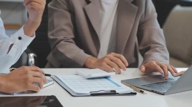 Finansal rapor üzerinde birlikte çalışan genç iş adamları şık bir ofiste iş ve finans temasını ön plana çıkarıyorlar..