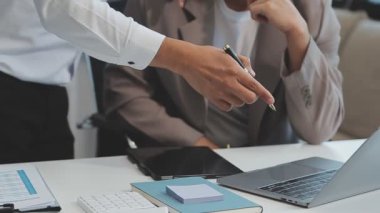 Finansal rapor üzerinde birlikte çalışan genç iş adamları şık bir ofiste iş ve finans temasını ön plana çıkarıyorlar..