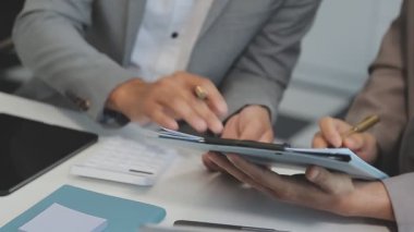 Finansal rapor üzerinde birlikte çalışan genç iş adamları şık bir ofiste iş ve finans temasını ön plana çıkarıyorlar..