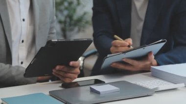 Şık bir ofis ortamında iş ve finans sektörünü vurgulayan yeni bir projeyi gözden geçiren bir iş dünyası uzmanı ekibi.