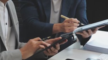 Şık bir ofis ortamında iş ve finans sektörünü vurgulayan yeni bir projeyi gözden geçiren bir iş dünyası uzmanı ekibi.