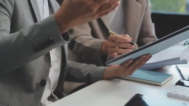 Şık bir ofis ortamında iş ve finans sektörünü vurgulayan yeni bir projeyi gözden geçiren bir iş dünyası uzmanı ekibi.