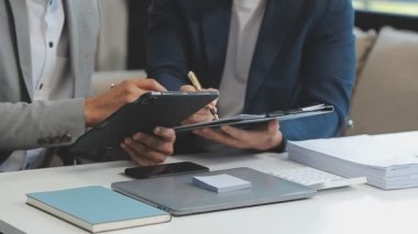 Şık bir ofis ortamında iş ve finans sektörünü vurgulayan yeni bir projeyi gözden geçiren bir iş dünyası uzmanı ekibi.