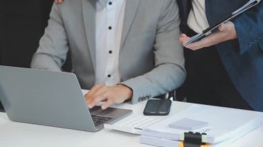 Şık bir ofis ortamında iş ve finans sektörünü vurgulayan yeni bir projeyi gözden geçiren bir iş dünyası uzmanı ekibi.