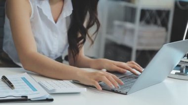 Bilgisayarda çalışan genç iş kadınının portresi modern bir ofis, iş ve finans konsepti arka planında.