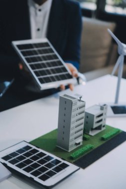 İki Genç Mühendis Güneş Hücresi Kurulum Toplantısı ve İş Tartışması Uzmanı. Ofis Odası 'nda Fabrika İnşaat Planlı Çatı Üzerine Güneş Fotovoltaik Panelleri Kurmayı Planlıyorum.