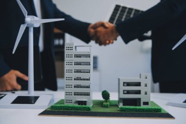 İki Genç Mühendis Güneş Hücresi Kurulum Toplantısı ve İş Tartışması Uzmanı. Ofis Odası 'nda Fabrika İnşaat Planlı Çatı Üzerine Güneş Fotovoltaik Panelleri Kurmayı Planlıyorum.