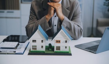 Emlakçı ev satın alma anlaşmasının şartları hakkında konuştu ve müşteriden sözleşmeyi yasal hale getirmek için belgeleri imzalamasını istedi, ev satışları ve ev sigortası kavramı.