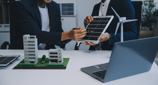 Два молодых инженера специализируются на солнечных батареях. Планирование установки солнечных фотоэлектрических панелей на крыше в офисной комнате с планом заводского строительства.