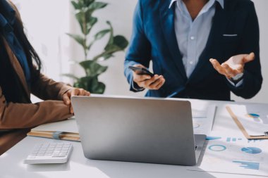 İş ekibi ile yeni başlangıç planı ve tartışma için proje bilgilerini dizüstü bilgisayar ve dijital tablet ile mali strateji bir modern iş salonda çalışıyor.