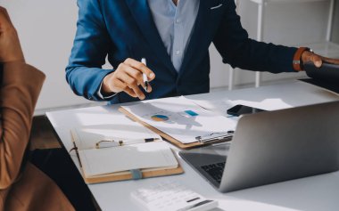 İş ekibi ile yeni başlangıç planı ve tartışma için proje bilgilerini dizüstü bilgisayar ve dijital tablet ile mali strateji bir modern iş salonda çalışıyor.