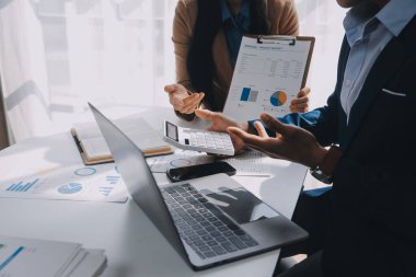 İş ekibi ile yeni başlangıç planı ve tartışma için proje bilgilerini dizüstü bilgisayar ve dijital tablet ile mali strateji bir modern iş salonda çalışıyor.