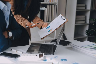 İş ekibi ile yeni başlangıç planı ve tartışma için proje bilgilerini dizüstü bilgisayar ve dijital tablet ile mali strateji bir modern iş salonda çalışıyor.