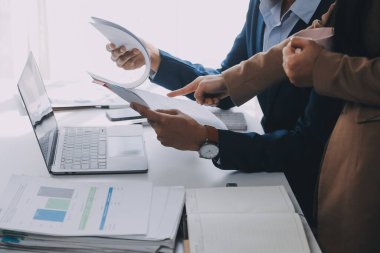 İş ekibi ile yeni başlangıç planı ve tartışma için proje bilgilerini dizüstü bilgisayar ve dijital tablet ile mali strateji bir modern iş salonda çalışıyor.