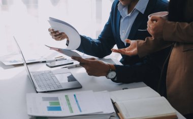 İş ekibi ile yeni başlangıç planı ve tartışma için proje bilgilerini dizüstü bilgisayar ve dijital tablet ile mali strateji bir modern iş salonda çalışıyor.