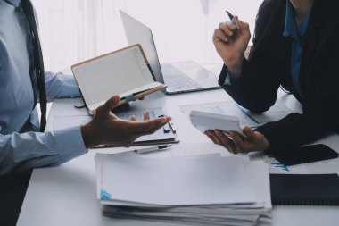 İş ekibi ile yeni başlangıç planı ve tartışma için proje bilgilerini dizüstü bilgisayar ve dijital tablet ile mali strateji bir modern iş salonda çalışıyor.