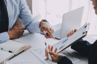 İş ekibi ile yeni başlangıç planı ve tartışma için proje bilgilerini dizüstü bilgisayar ve dijital tablet ile mali strateji bir modern iş salonda çalışıyor.