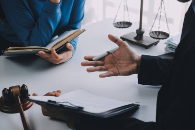 Adalet ve hukuk kavramı. Hukuk Müşaviri tokmak ve yasal hukuk veya yasal ile imzalanmış bir sözleşme istemciye sunar arka planda hukuk firmasında takım toplantısı