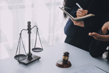 Adalet ve hukuk kavramı. Hukuk Müşaviri tokmak ve yasal hukuk veya yasal ile imzalanmış bir sözleşme istemciye sunar arka planda hukuk firmasında takım toplantısı