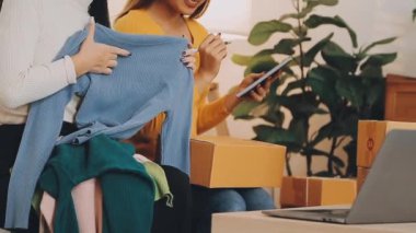 vlogger, blog yazarı küçük KOBİ iş kadını Asyalı güzel kadınlar kıyafetleri canlı yayın satışı internet üzerinden satışı, ev ofisinde mevcut ürün detaylarını gösterme, girişimci ekommerce