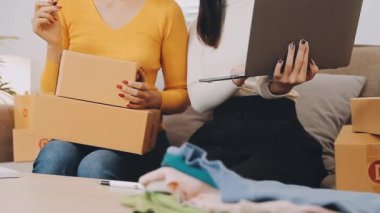 vlogger, blog yazarı küçük KOBİ iş kadını Asyalı güzel kadınlar kıyafetleri canlı yayın satışı internet üzerinden satışı, ev ofisinde mevcut ürün detaylarını gösterme, girişimci ekommerce