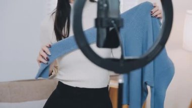 vlogger, blog yazarı küçük KOBİ iş kadını Asyalı güzel kadınlar kıyafetleri canlı yayın satışı internet üzerinden satışı, ev ofisinde mevcut ürün detaylarını gösterme, girişimci ekommerce