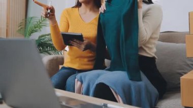 vlogger, blog yazarı küçük KOBİ iş kadını Asyalı güzel kadınlar kıyafetleri canlı yayın satışı internet üzerinden satışı, ev ofisinde mevcut ürün detaylarını gösterme, girişimci ekommerce