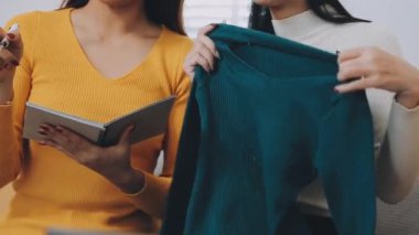 vlogger, blog yazarı küçük KOBİ iş kadını Asyalı güzel kadınlar kıyafetleri canlı yayın satışı internet üzerinden satışı, ev ofisinde mevcut ürün detaylarını gösterme, girişimci ekommerce