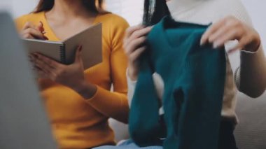 vlogger, blog yazarı küçük KOBİ iş kadını Asyalı güzel kadınlar kıyafetleri canlı yayın satışı internet üzerinden satışı, ev ofisinde mevcut ürün detaylarını gösterme, girişimci ekommerce