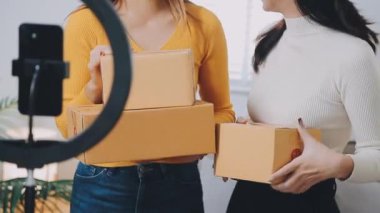 vlogger, blog yazarı küçük KOBİ iş kadını Asyalı güzel kadınlar kıyafetleri canlı yayın satışı internet üzerinden satışı, ev ofisinde mevcut ürün detaylarını gösterme, girişimci ekommerce