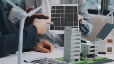 Çağdaş ofis ortamında çevre dostu yeni bir kompleks projesinde işbirliği yapan genç profesyonellerden oluşan bir ekip.