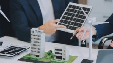 Çağdaş ofis ortamında çevre dostu yeni bir kompleks projesinde işbirliği yapan genç profesyonellerden oluşan bir ekip.